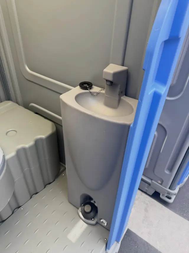 Foot-pump sink with soap dispenser inside a deluxe porta potty